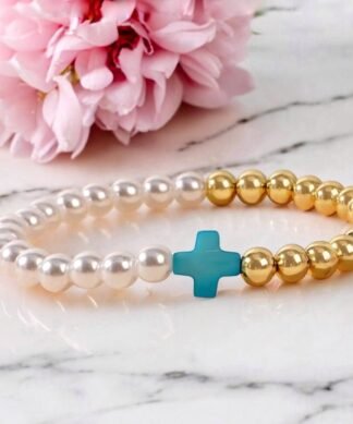 Bracelet fantaisie femme avec perles dorées et nacrées et croix turquoise centrale, bijou tendance et lumineux.