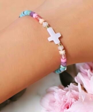 bracelet fantaisie multicolore pastel avec croix blanche centrale, bijou féminin à message doux et tendance à porter avec un look estival ou bohème